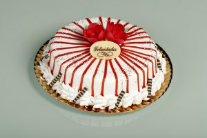 Tarta de chocolate blanco con cobertura de nata y mermelada de fresa.