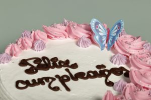 Tarta latina decorada con nata rosa y morada, relleno de tu elección.