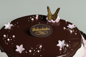 Tarta de fresa con nata, chocolate y detalles de nata sabor fresa.