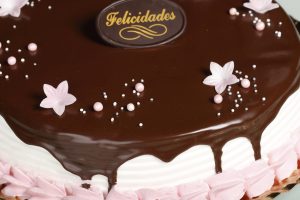 Tarta de fresa con nata, chocolate y detalles de nata sabor fresa.