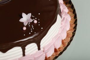 Tarta de fresa con nata, chocolate y detalles de nata sabor fresa.