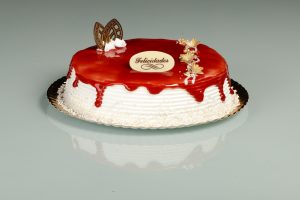 Tarta Latina decorada con glaseado de fresa rojo brillante y relleno a elegir.