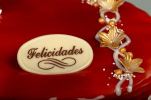 Tarta Latina decorada con glaseado de fresa rojo brillante y relleno a elegir.