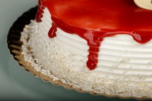 Tarta Latina decorada con glaseado de fresa rojo brillante y relleno a elegir.