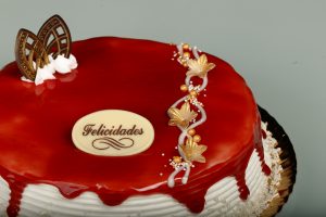 Tarta Latina decorada con glaseado de fresa rojo brillante y relleno a elegir.
