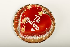 Corazón de San Valentín con glaseado rojo brillante sobre bizcocho de vainilla.