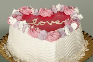 Corazón glaseado rosa de San Valentín con bizcocho de vainilla.