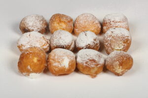 Caja de 12 buñuelos de viento surtidos rellenos de nata, crema, chocolate y otros sabores artesanos.
