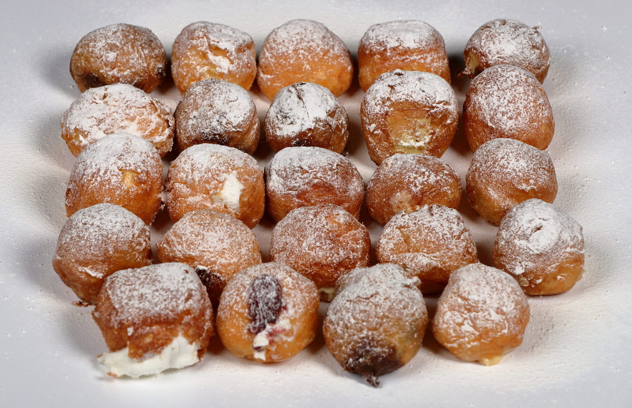 Caja grande de 24 buñuelos de viento surtidos rellenos de sabores artesanos.