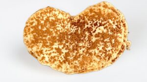 Palmerita de tiramisú con hojaldre dorado, rellena de crema de mascarpone, café y cacao.